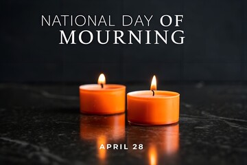 Two flickering orange votive candles rest upon a dark reflective surface commemorating the solemn occasion of the national day of mourning observed every april twenty eighth.