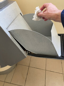 Man's hand throws a napkin into an open garbage chute. Manhole door of garbage chute indoor of apartment building. Convenient waste collection system