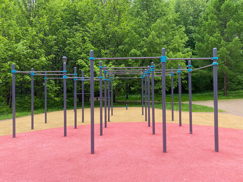 Sports ground in urban park featuring calisthenics equipment, pull up bars, horizontal bars and monkey bars for outdoor workout and street training