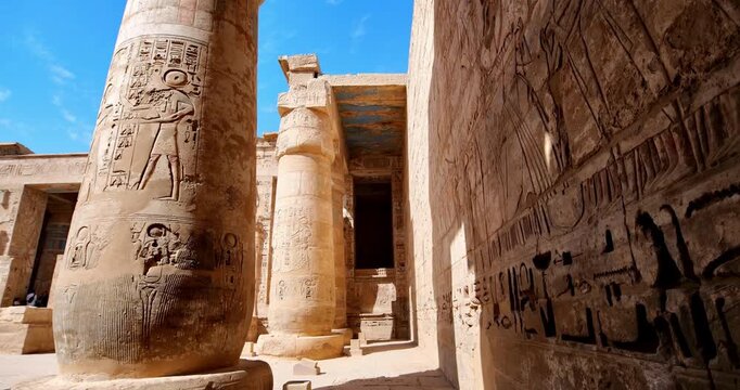 Medinet Habu temple painted ceiling with vulture goddess Nekhbet and hieroglyphs in red orange colors in Luxor Egypt, ancient Egyptian astronomical decorations and cartouches .