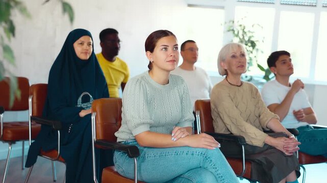 Young woman listening to lecture while sitting on chair in office 