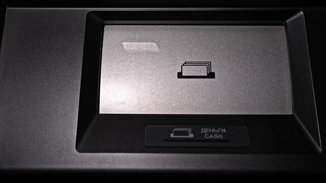 Closeup view of ATM slot counting banknotes and dispensing cash. Automated teller machine processing withdrawal and releasing money at end of operation.