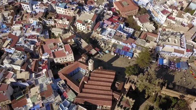 Stunning HD top-down aerial of Chefchaouen's vibrant blue buildings and red tiled rooftops. Captures the unique urban texture of the Blue City. Ideal for travel and design projects.