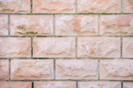 Primer plano de pared de bloques de piedra rectangular con textura labrada y juntas regulares.