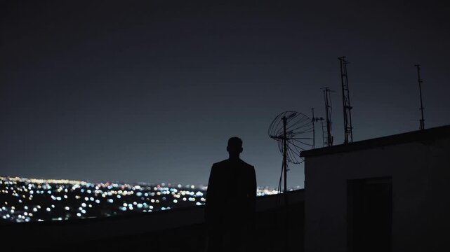 Silhouette by rooftop antennas overlooking city lights, lone figure leans against concrete parapet near broadcast masts, distant residential lights twinkling, deep blueblack palette, subtle
