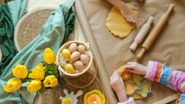 Children making Easter cookies with tulips and eggs, a festive spring baking activity