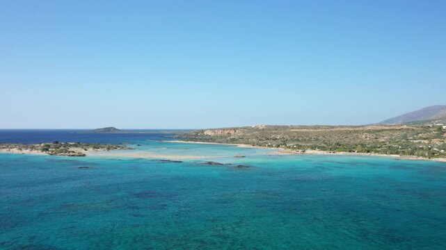 Stunning aerial view of Elafonisi beach with turquoise waters and sandy coastline on a clear day in Crete, Greece.