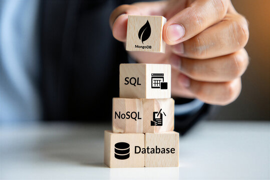 Hand holding a wooden block with a leaf symbol and the word MongoDB above other blocks representing SQL NoSQL and Database concepts