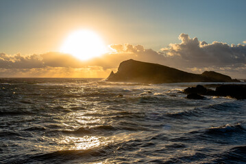 Obraz premium Sunset over rocky island and sea