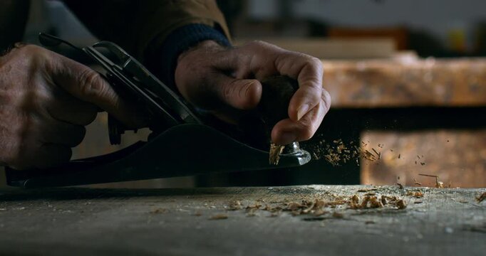 Slow Motion close Up of Carpenter Using Hand Plane To Smooth Wooden Board Surface at 1000 fps.
