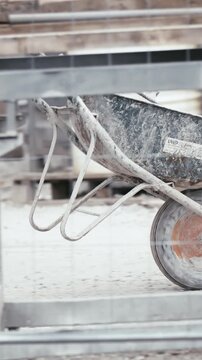Worker driving around wheelbarrow long shot