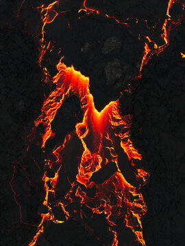 Aerial view of fiery lava flows like arteries of the earth, pulsing with molten energy against the stark black landscape, Grindavik, Grindavikurbaer, Iceland.