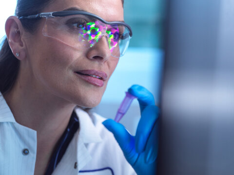 Chemist conducting pharmaceutical research in laboratory with safety glasses