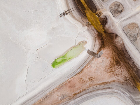 Aerial view of the parched earth, where muted whites meet earthy browns and a splash of vibrant green forms an oasis, Old Chandler, Western Australia, Australia.