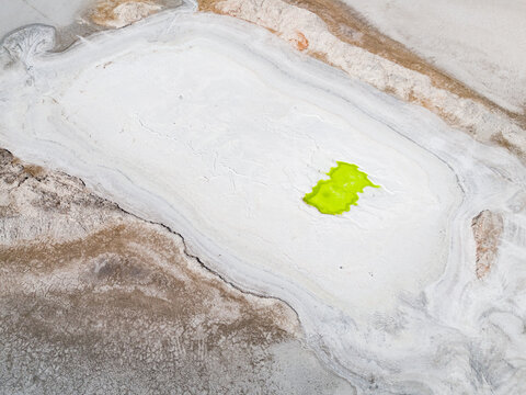 Aerial view of a vivid green pool nestled in a white and grey landscape, Old Chandler Potash Mine Site, Western Australia, Australia.