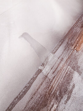 Aerial view of a weathered surface, partially obscured by a dense fog, revealing contrasting textures and tones, Old Chandler Potash Mine Site, Western Australia, Australia.