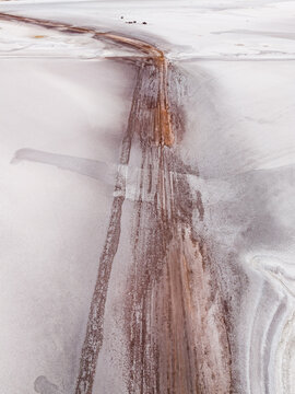 Aerial view of contrasting textures and tones, where stark white expanses meet the earthy hues of the mine's remnants, Old Chandler Potash Mine Site, Western Australia, Australia.