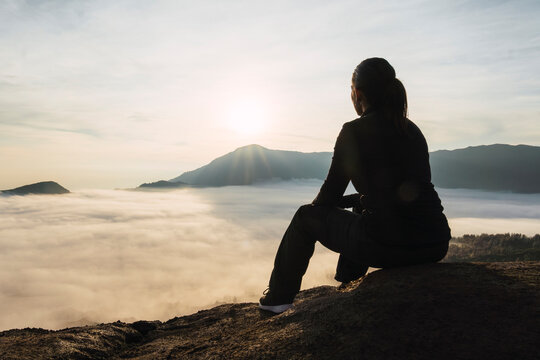 Traveler overlooking volcano crater at sunrise in Java Indonesia