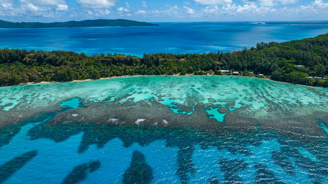 Aerial view of turquoise lagoon and reef of Aukena island in French Polynesia