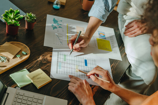 Colleagues analyzing business graphs and data at office desk