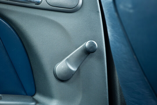 Manual car window crank handle on interior door panel