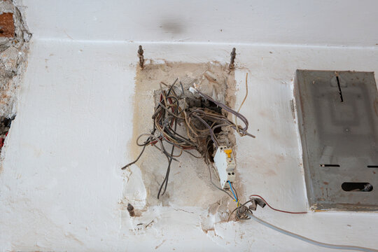Dangerous exposed electrical wiring in a wall during renovation