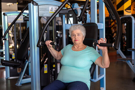 Senior Woman Over 70 Doing Strength Training on Chest Press Machine in Gym, Active Aging, Muscle Maintenance and Healthy Lifestyle Concept
