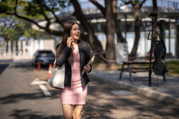 Fototapeta premium Professional businesswoman talking on phone walking in city