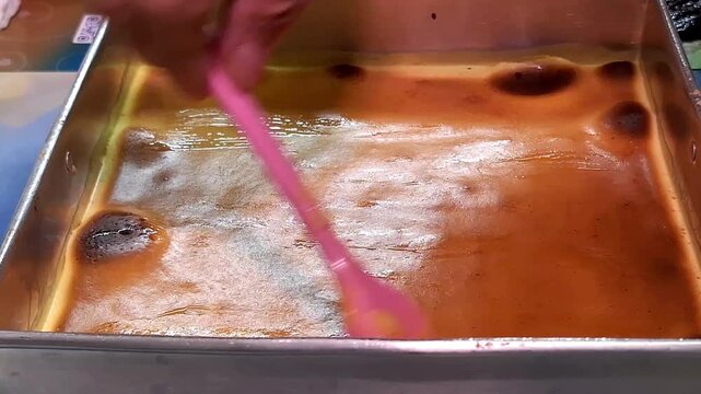 Thousand-layer cake (Lapis Legit) out of the oven, spread with butter before continuing baking.