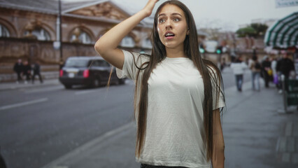 Teen girl with long hair and braces, hand on forehead gesture and nervous smile wearing white...