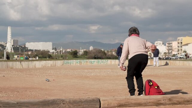 P&eacute;tanque, une femme joue &agrave; une partie de boules de p&eacute;tanque - fameux jeux de boules Marseillais - Marseille mondial de la p&eacute;tanque - Vid&eacute;o ralentie 4k	
