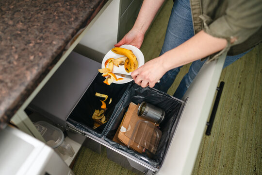 Sorting food waste and recyclables into kitchen bins for sustainability