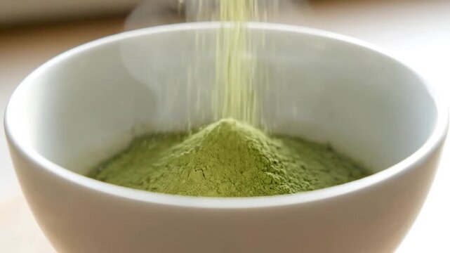 Green Matcha Powder Being Poured into Bowl.