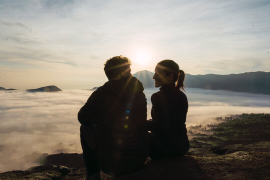 Romantic couple sitting together at sunrise on Mount Bromo Java