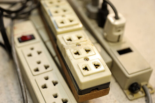 Old electrical extension cords plug is broken case damage and danger or connector voltage power burnt overload