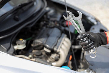 Obraz premium Auto mechanic holding wrench for fix service repairing and car care maintenance servicing change spare part engine problem or insurance support or range of car check or training workshop.