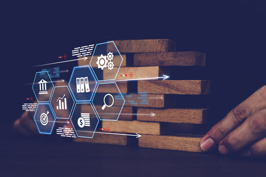 Close-up hand prevents and choose wooden block not falling with financial risk management icons for strategic planning and business challenge plan or safety insurance.