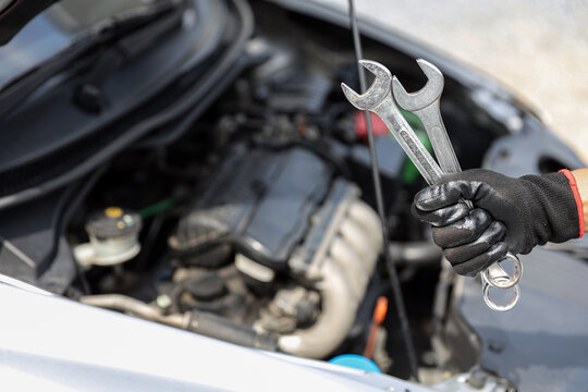Auto mechanic holding wrench for fix service repairing and car care maintenance servicing change spare part engine problem or insurance support or range of car check or training workshop.