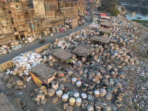 Aerial view of plastic waste recycling zone with plastic bags and makeshift shelters lining the Buriganga River, Dhaka, Dhaka Division, Bangladesh.