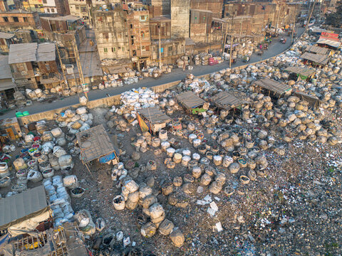 Aerial view of a vast expanse of plastic waste contrasting sharply with the adjacent buildings along the Buriganga River, Dhaka, Dhaka Division, Bangladesh.