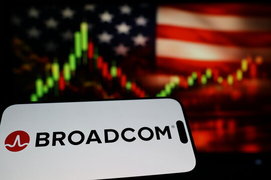 Kiel, Germany - 03-03-2026: US semiconductor company Broadcom Inc. logo on smartphone against US flag and rising stock market candlestick chart concept