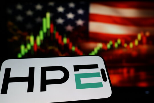 Kiel, Germany - 03-03-2026: US enterprise technology company Hewlett Packard Enterprise Company logo on smartphone against US flag and rising stock market candlestick chart concept