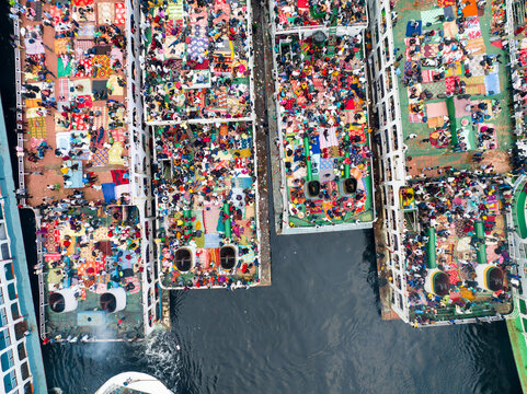 Aerial view of a multitude of people gathered on boats, a vibrant tapestry against the dark water, Dhaka, Dhaka Division, Bangladesh.
