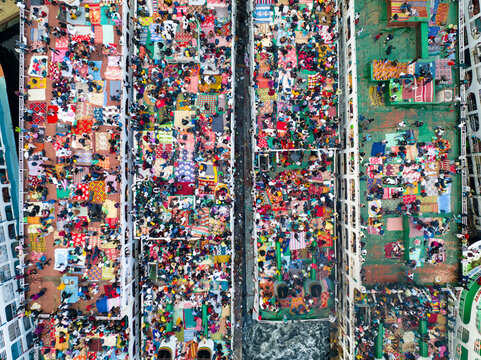 Aerial view of a dense gathering of people praying on mats, their colorful clothes creating a vibrant tapestry, Dhaka, Dhaka Division, Bangladesh.