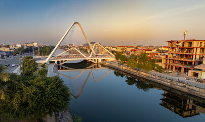 Obraz premium The modern Cầu Bông Lau, a striking white arch bridge, reflecting beautifully in the calm water. Ninh Binh, Vietnam.