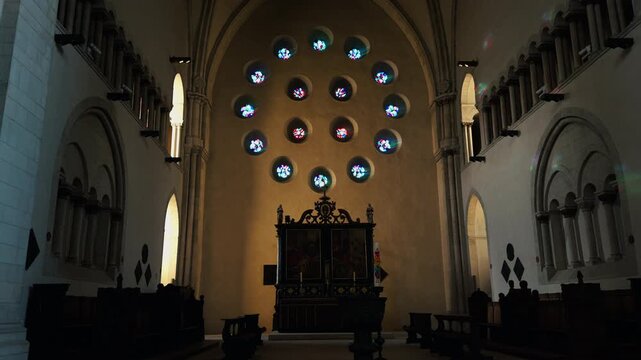 Interior of St Paulus Dom in M&uuml;nster, Germany featuring circular stained glass windows above the altar. Historic cathedral architecture with symmetrical design and soft natural light creating a spirit