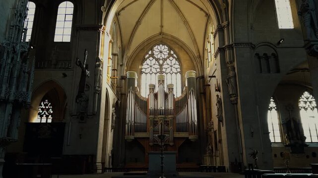 Grand pipe organ inside St Paulus Dom Cathedral in M&uuml;nster, Germany. Gothic church interior with vaulted ceiling, stained glass windows and historic religious architecture illuminated by natural light