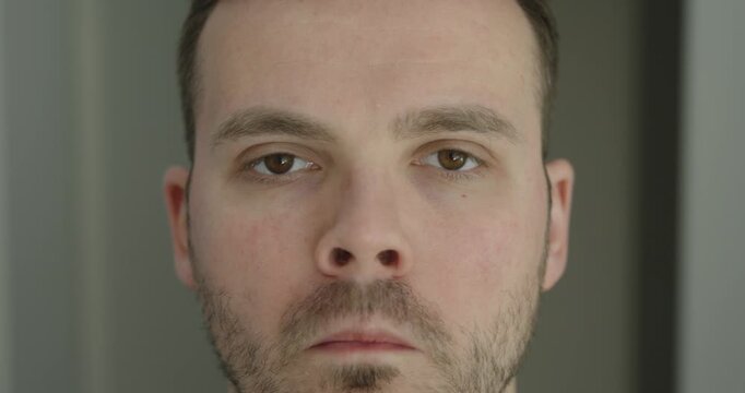 Close-up of a man repeatedly scrunching his nose due to a nervous tic. Concept of involuntary facial movement, stress, anxiety and neurological habit.