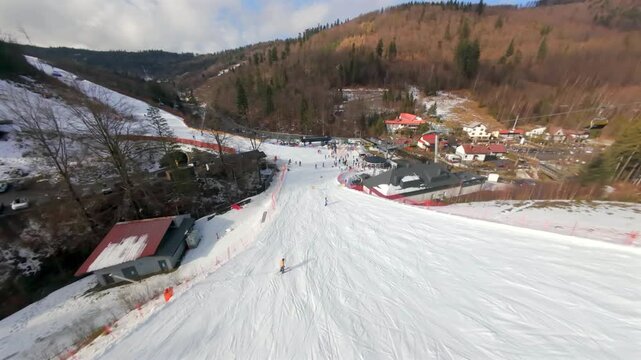 Fast FPV flight over the snowy slopes of Solisko. Skiers and snowboarders enjoying a winter day in the Beskids.