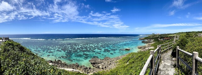 Panoramic aerial view of beautiful emerald green coral reef sea and blue sky in Miyako island Okinawa Japan. Tropical resort landscape scenery with coast cliff and walking path on sunny day. © なにがしあれこれ